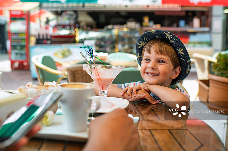 可爱的小男孩在咖啡馆吃冰淇淋图片素材