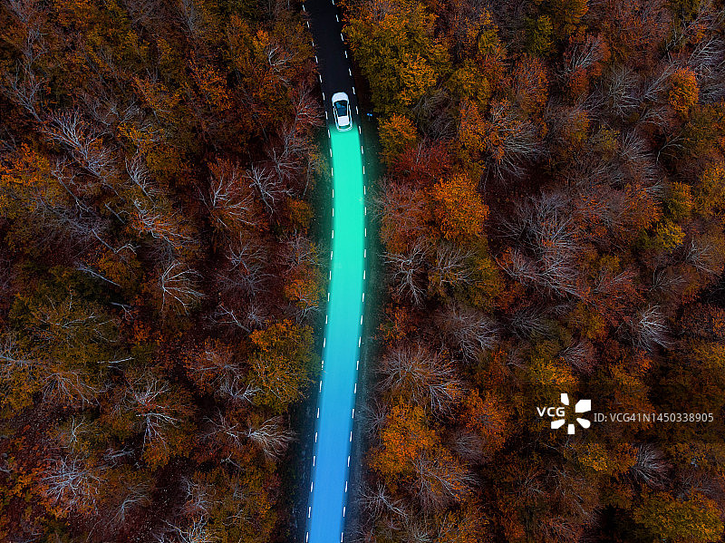 秋季森林中行驶的电动汽车航拍图片素材