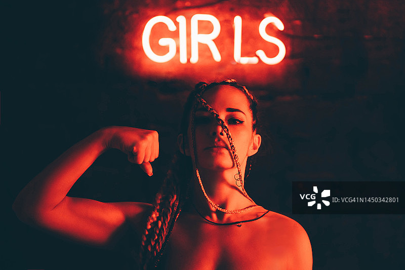 女孩力量。霓虹灯照亮的美丽女人肖像。图片素材
