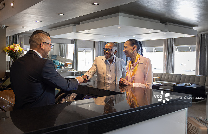 情侣在酒店前台领取房间钥匙图片素材