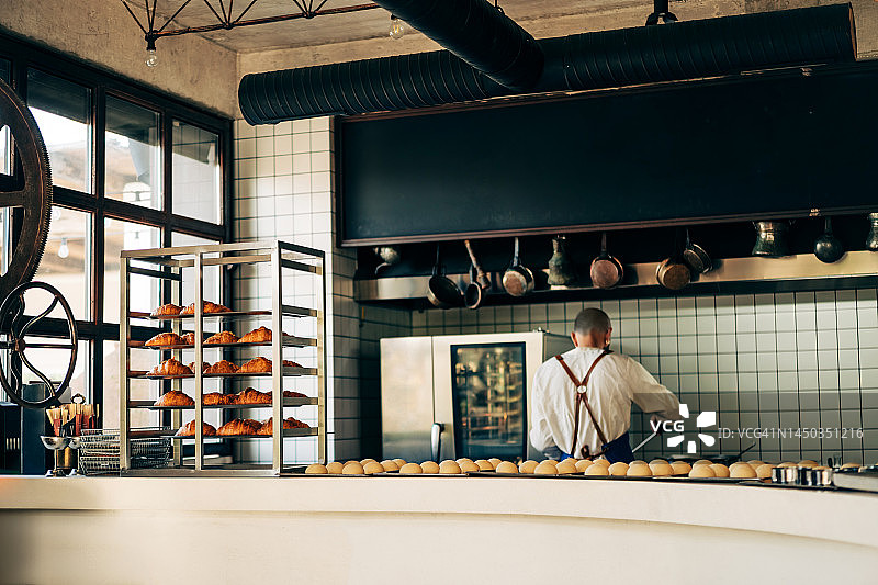 厨师在法式面包店烹饪新鲜羊角面包图片素材