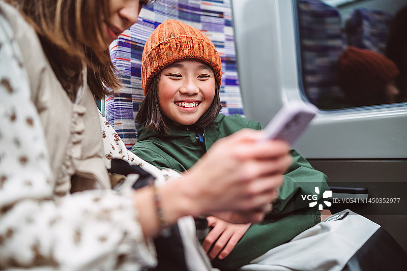 旅途中，母亲和女儿开心地使用智能手机图片素材