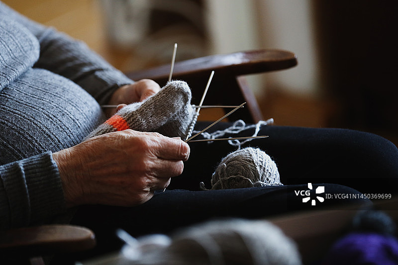 老妇人编织灰色羊毛袜子的手图片素材