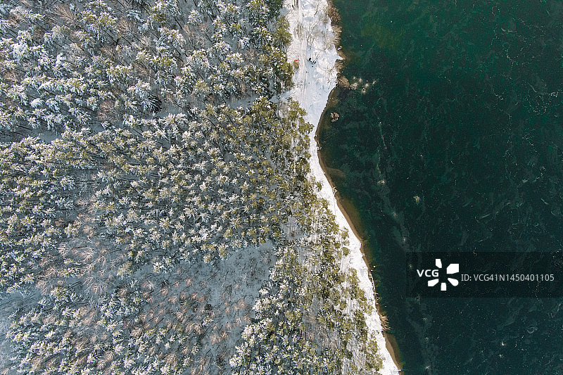 冰冷的冬季森林和海水海湾的阴阳顶视图图片素材