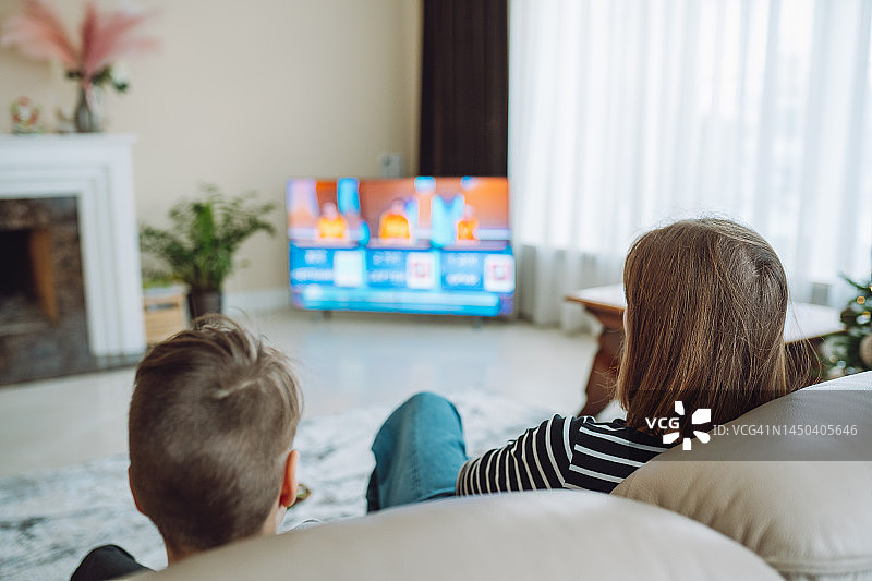 家庭视频流媒体服务，母亲和儿子周末在家观看在线电视电影放松图片素材