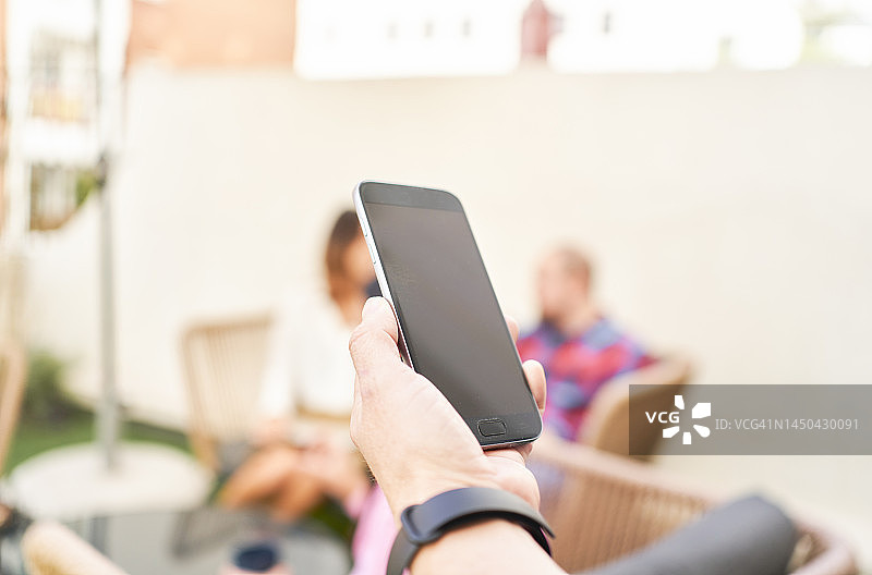 戴手表的男人手持智能手机特写图片素材