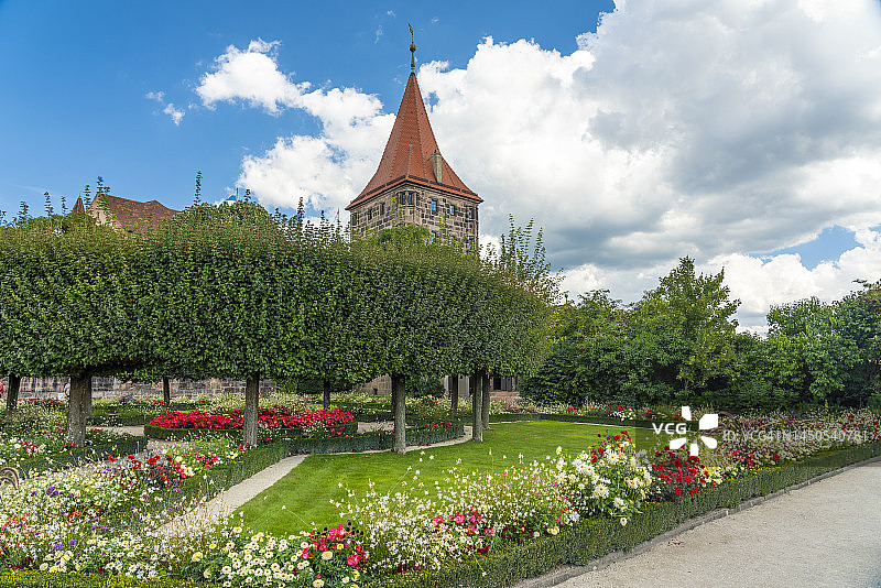 德国巴伐利亚纽伦堡城堡花园中盛开的鲜花与 Tiergartnertorturm图片素材