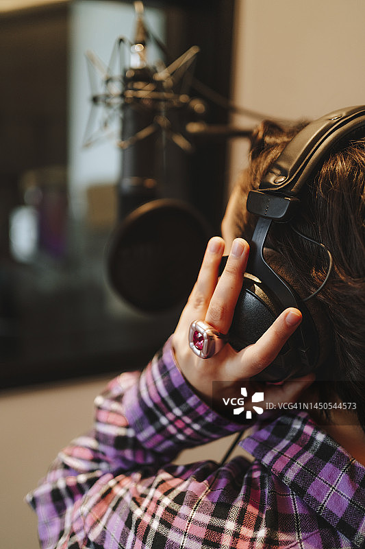 录音棚里歌手戴着耳机的手图片素材