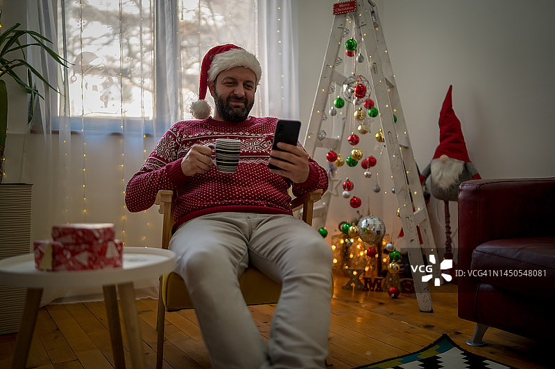 戴圣诞帽的男人用电话祝您新年快乐图片素材