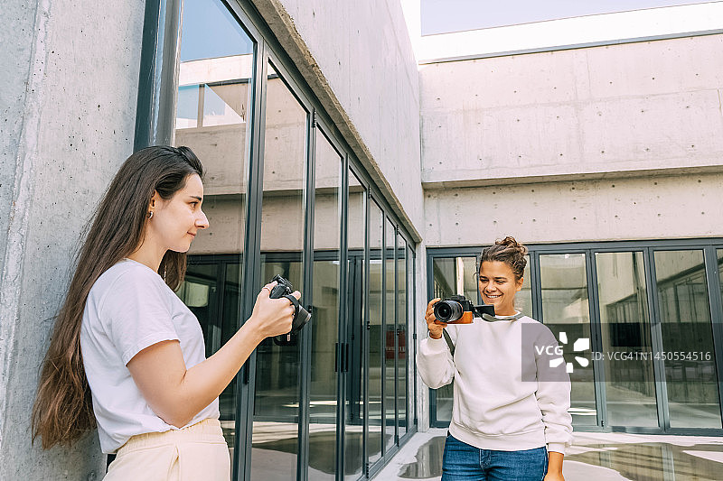 两个年轻女摄影师用相机一起工作，团队合作图片素材
