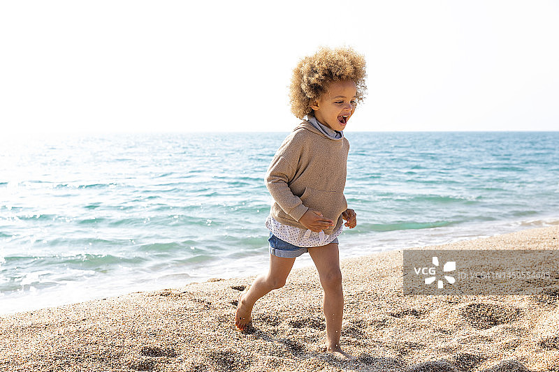 快乐女孩在海滩上奔跑图片素材