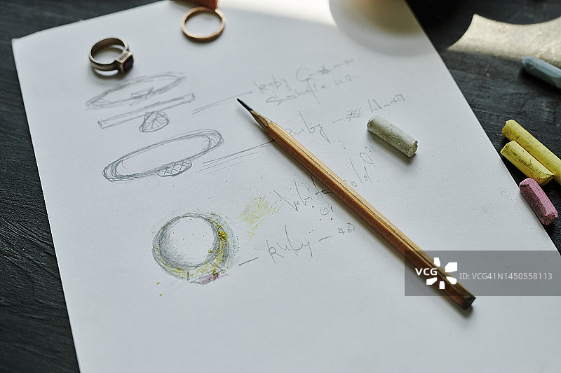 工作台上绘制戒指的纸质铅笔画图片素材