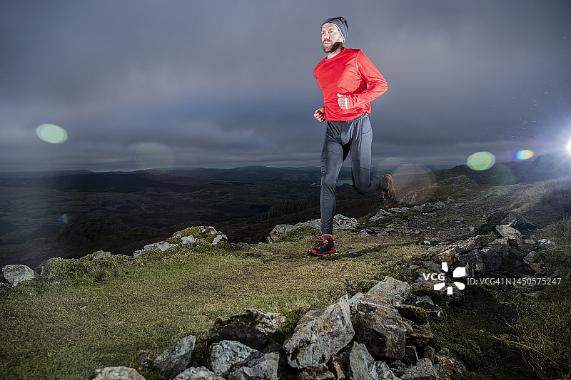 男子在黄昏时在山坡上慢跑图片素材