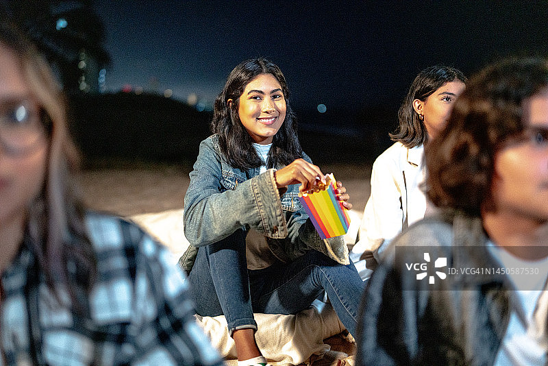 年轻女子在露天电影院吃爆米花的肖像照图片素材