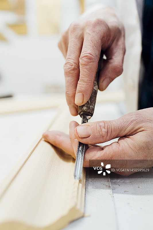 工匠在车间雕刻木制框架图片素材