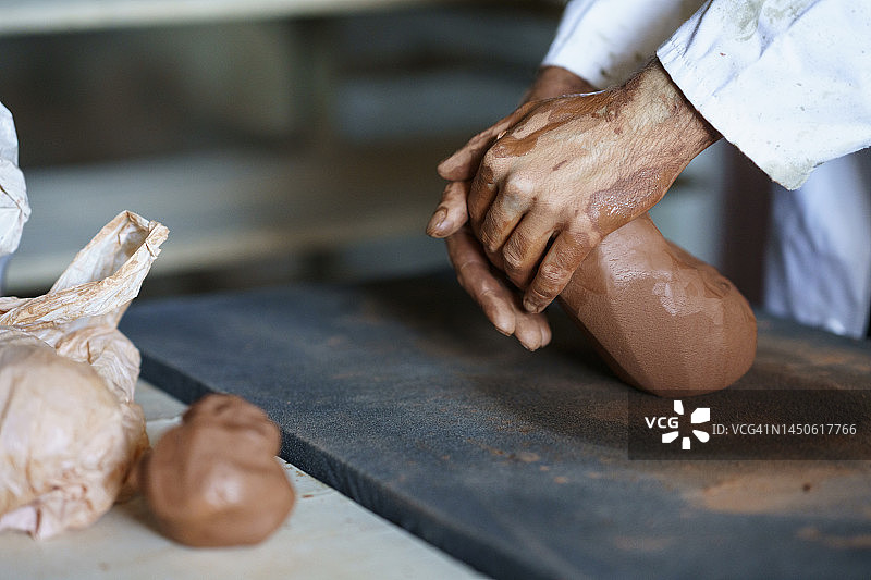 工匠在工作台上揉捏黏土图片素材