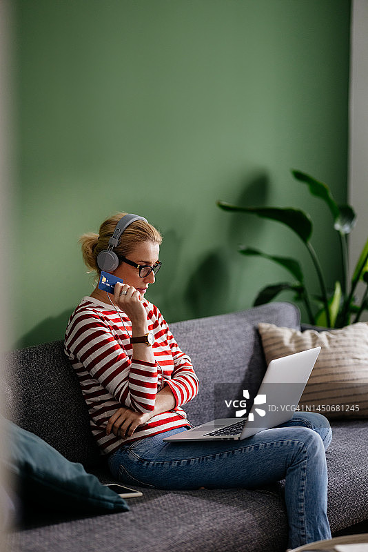 在家用信用卡和笔记本电脑进行网上购物的商务女性图片素材