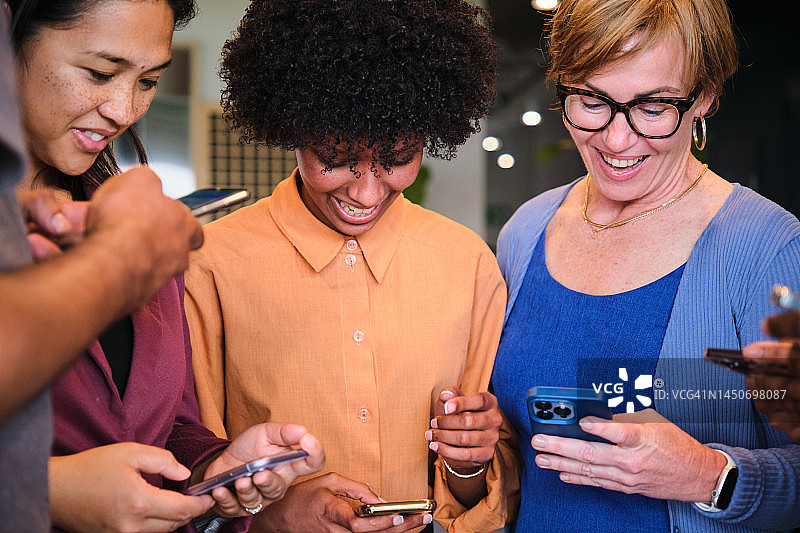 在工作休息期间查看手机的微笑女商人图片素材