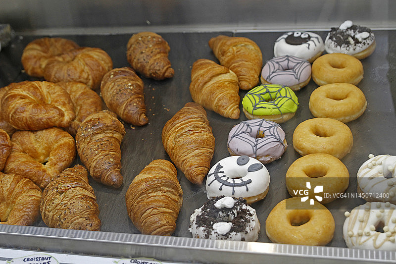 面包店摊位上的牛角包和甜甜圈图片素材