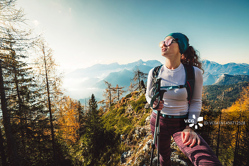 阳光明媚的秋日，登山的白人妇女享受温暖阳光图片素材