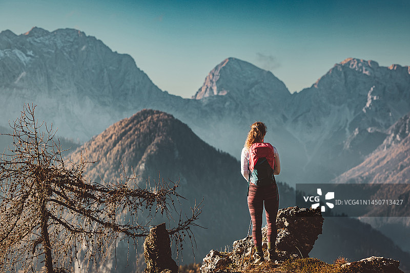女登山者欣赏秋日山景背影图片素材