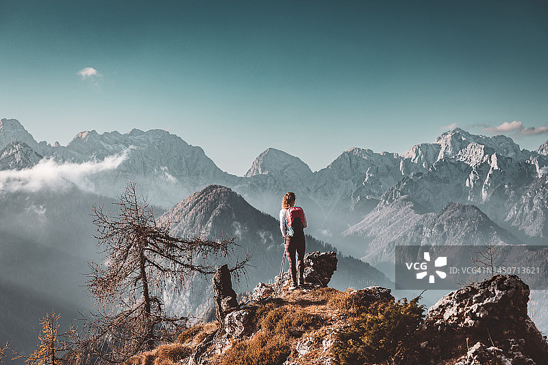 孤独的徒步女性在观景点欣赏阿尔卑斯山脉图片素材