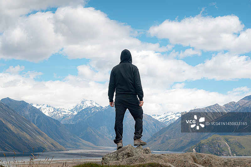 连帽男子在星期日山沉思新西兰阿尔卑斯山和阿什伯顿湖图片素材