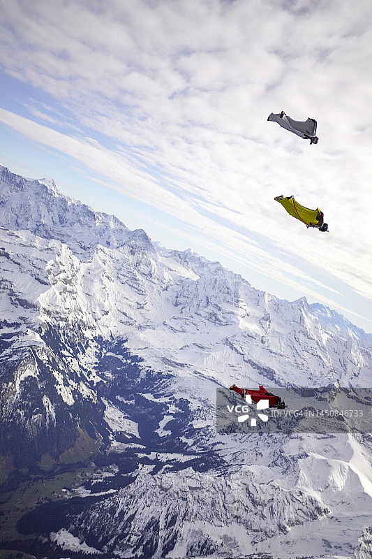 朋友们穿着翼装飞越瑞士阿尔卑斯山图片素材