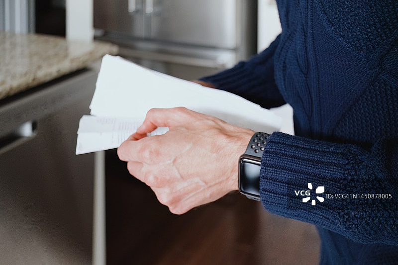 男人在厨房查看一堆收据图片素材