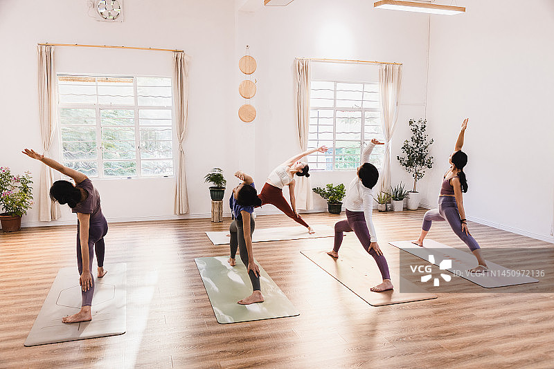 一群亚洲女性在瑜伽馆上瑜伽课图片素材