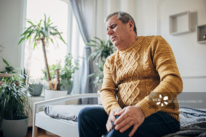 男人手按着疼痛的膝盖图片素材