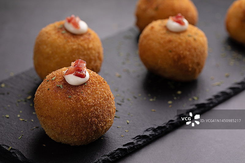 黑色背景下的伊比利亚火腿炸丸子图片素材