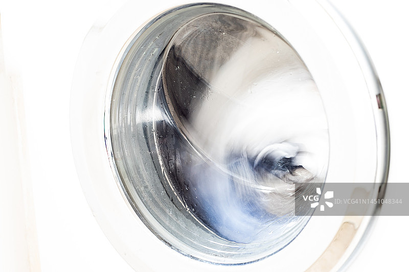 白色洗衣机和浅色衣物特写图片素材