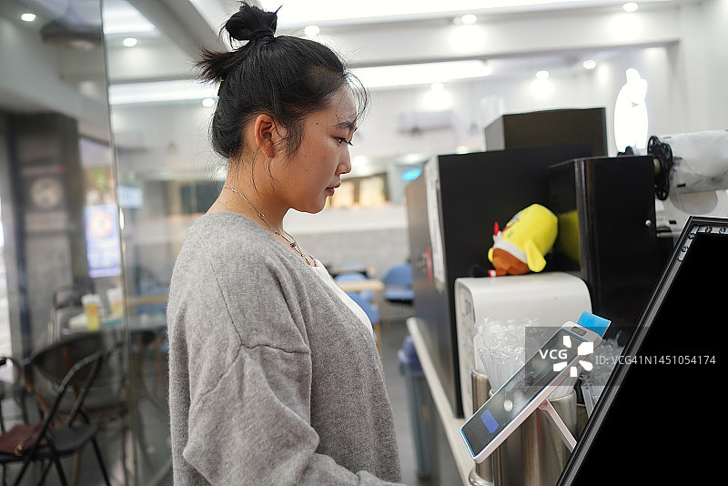 亚洲女性使用面部识别支付图片素材