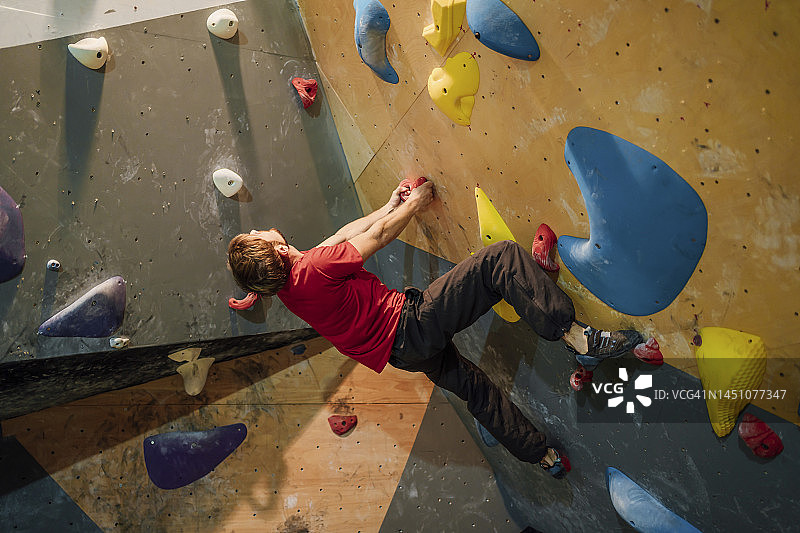 男子攀爬人工岩壁图片素材