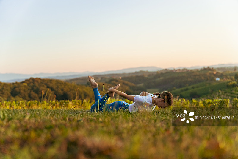 女人在日出时以晴朗的天空为背景练习弓步图片素材