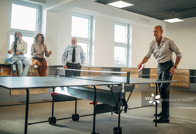 商业伙伴在工作中打乒乓球图片素材