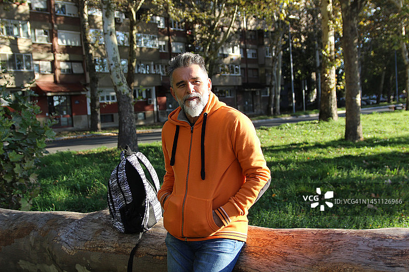 穿着橙色连帽衫的现代老年男子图片素材