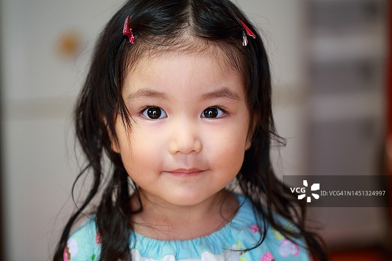 特写镜头下对着镜头微笑的可爱儿童肖像图片素材