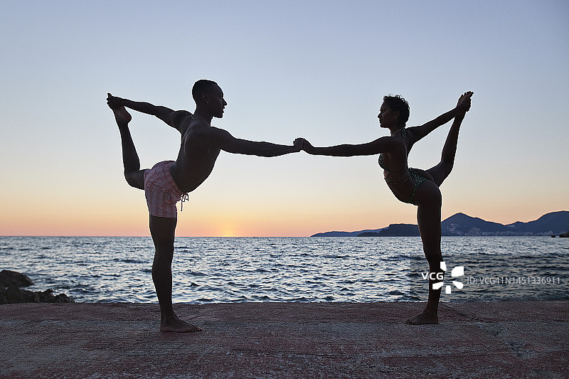 男人和女人一起练习Natrajasana瑜伽图片素材