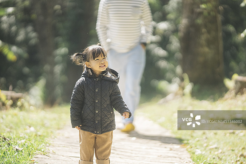 亚洲父亲带女儿在公园露营，学习生态知识图片素材