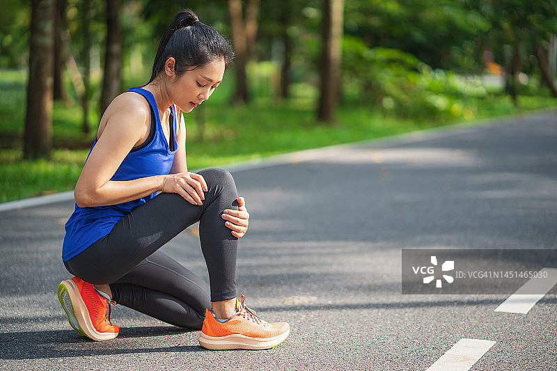 膝盖疼痛。运动损伤，女性在户外运动时膝盖疼痛。跑步运动中女性膝盖受伤图片素材
