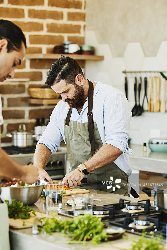 男子在烹饪课上切有机胡萝卜图片素材