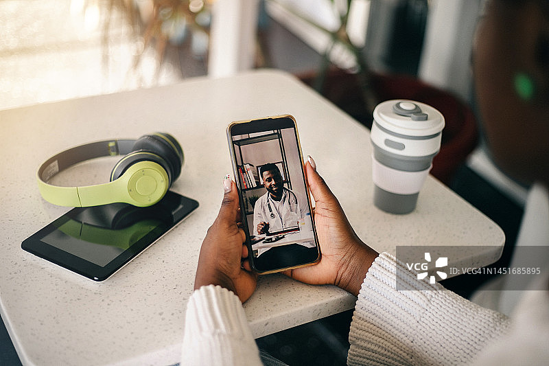 年轻的黑人女子在家中与医生进行视频通话图片素材