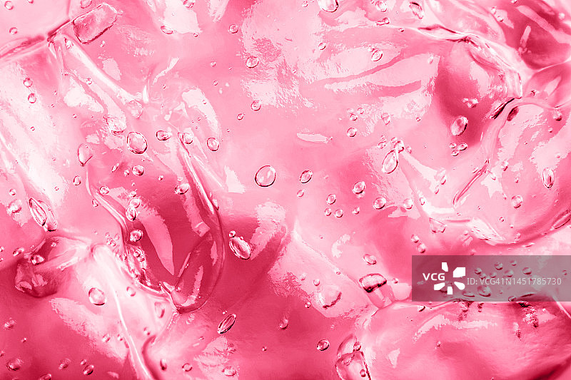 带气泡的Viva Magenta凝胶。用于涂抹面部的透明粉红色保湿精华液。化妆和护肤化妆品。2023年度代表色。图片素材