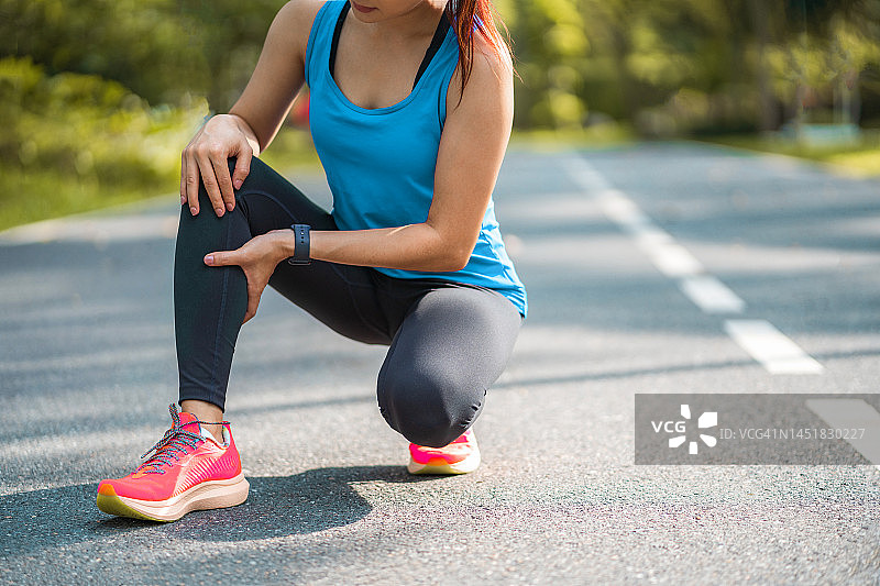 膝盖疼痛。运动损伤，女性在户外运动时膝盖疼痛。跑步运动中女性膝盖受伤图片素材