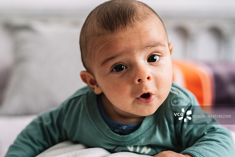 一个抬起头来的可爱婴儿的肖像照图片素材