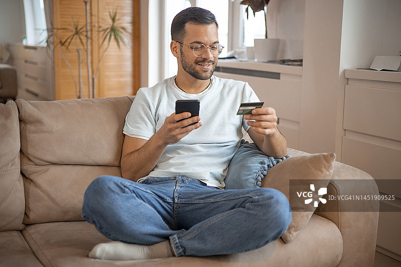 男人使用信用卡在线购物图片素材