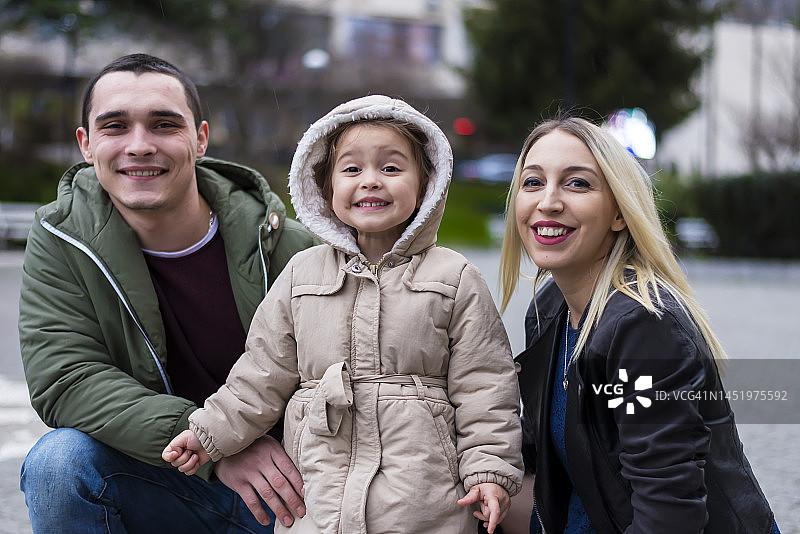 年轻夫妇和女儿在公园里玩耍图片素材