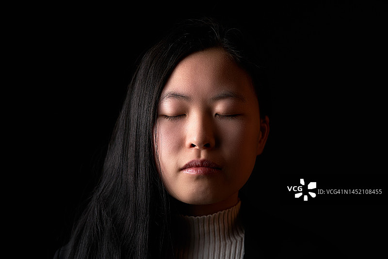 闭着眼睛的亚洲女人正面照图片素材